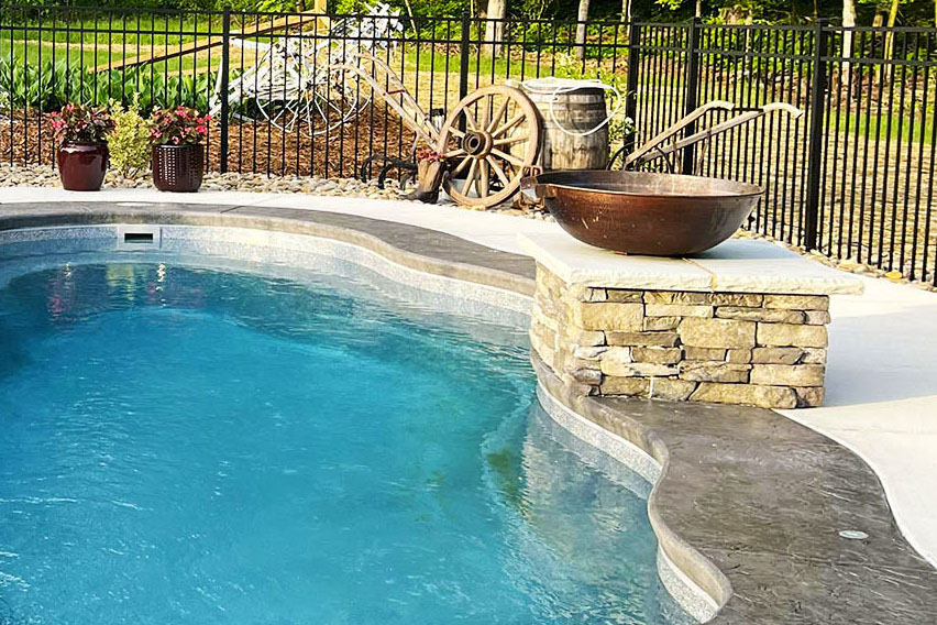 in-ground fiberglass pool with copper bowl waterfall